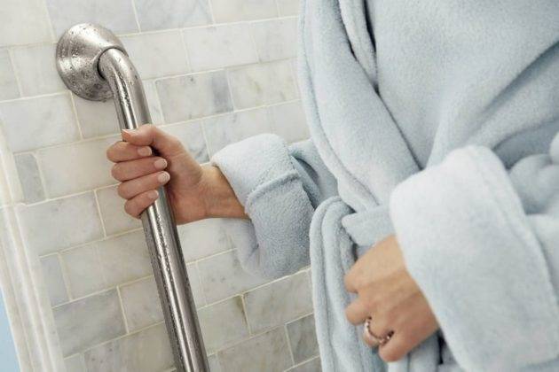 Metal Bathroom Grab Bar Being Held by a Woman's Hand Bathroom Grab Bar