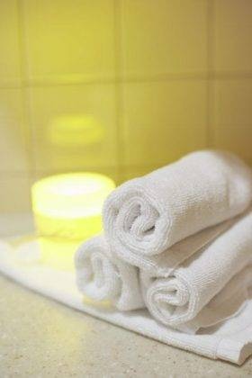 Rolled Towels Next to Candle Light Rolled Towels